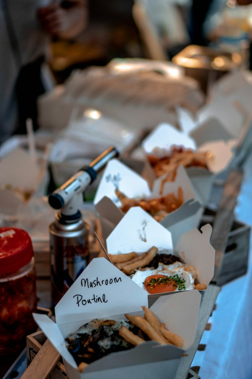 Mushroom poutine served in takeout containers at a market stall.