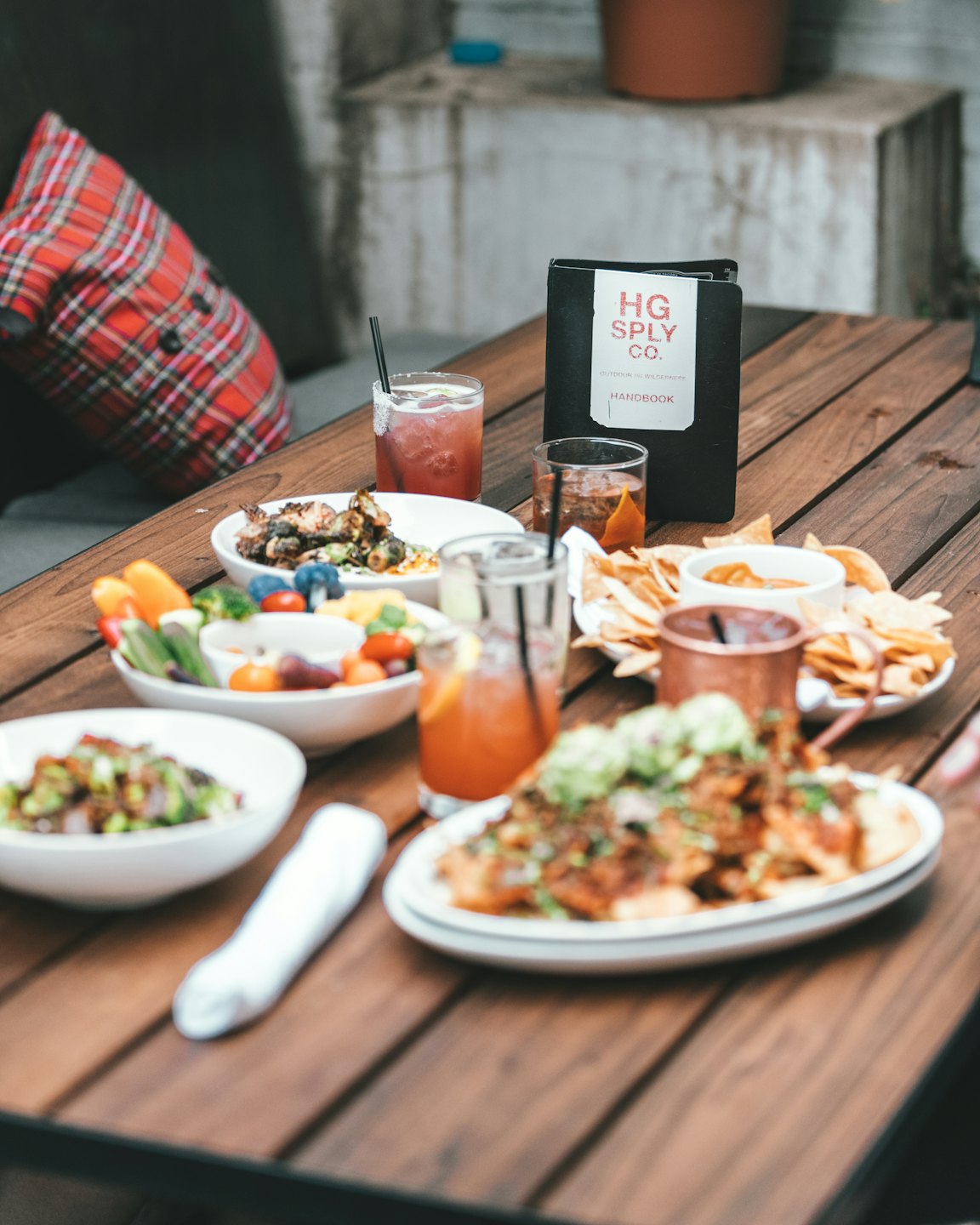 Appetizers and cocktails arranged on a rustic outdoor table.